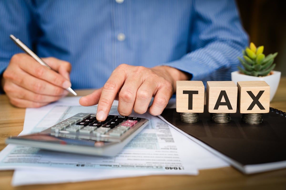 Tax professional preparing a client's income tax return with financial documents and calculator
